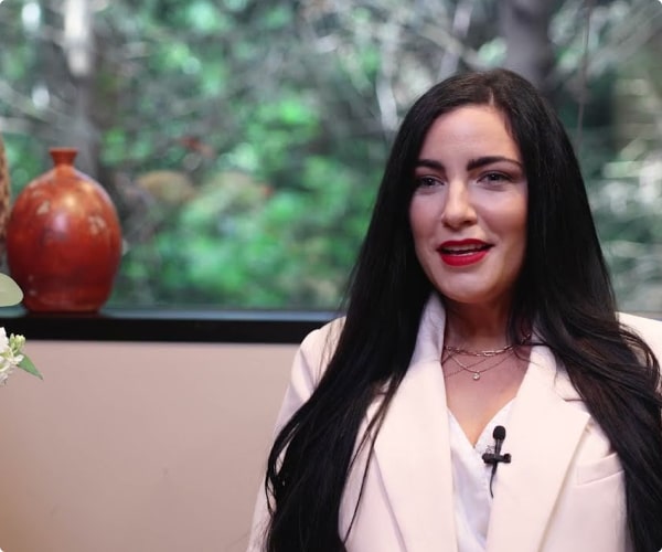 Jayme is smiling and sharing her positive experience with Dr. Ron Sherman