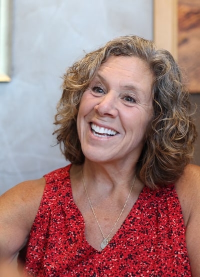 A woman in a red dress is smiling