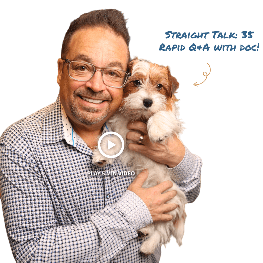 Dr. Ron Sherman holding a small dog and  warmly smiling