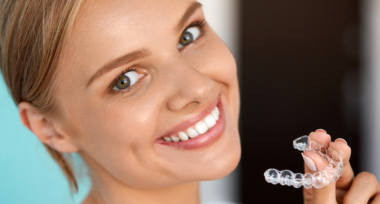 Young woman holding an Invisalign tray